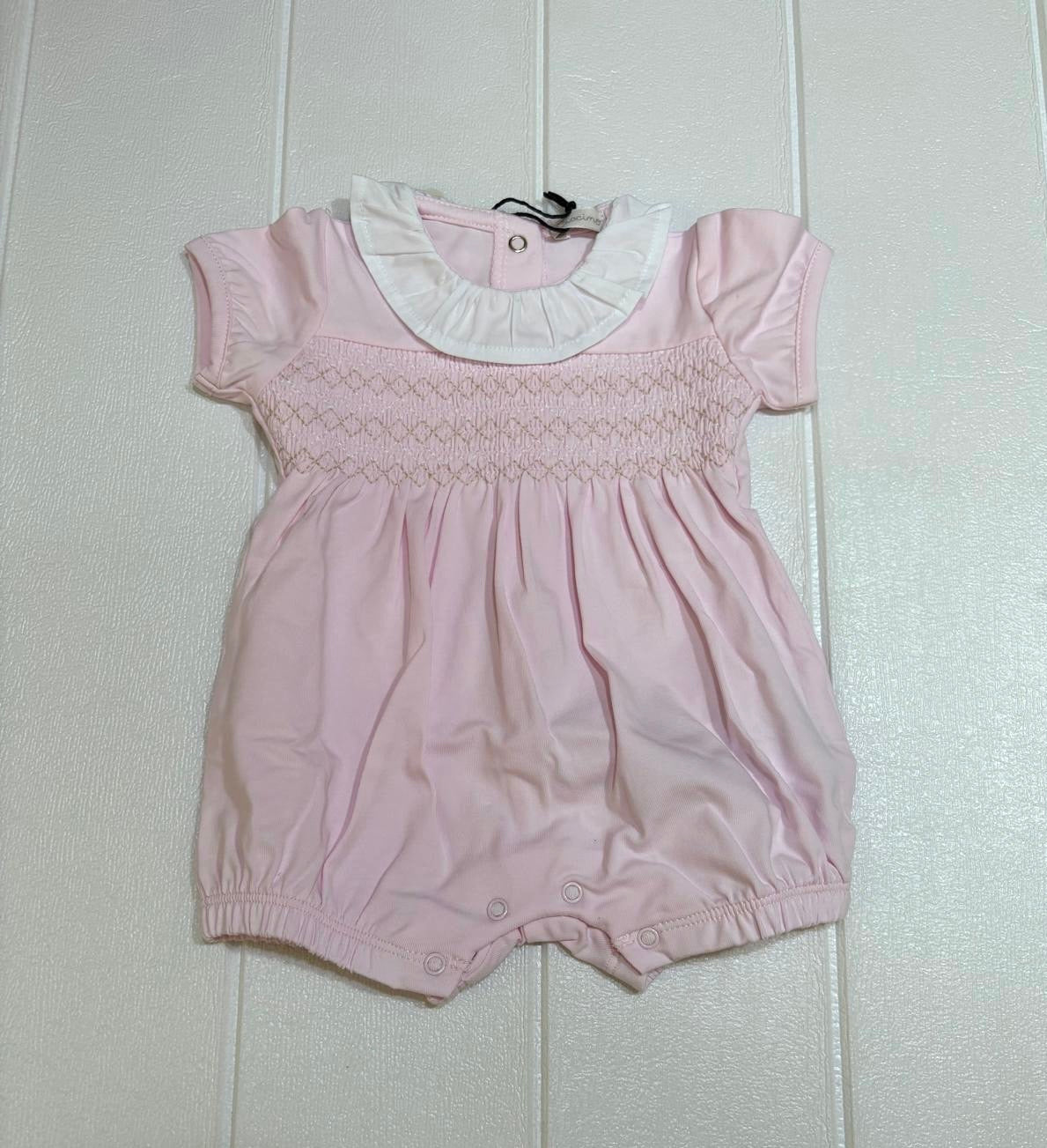 Pagliaccetto rosa con colletto bianco, ricamo in contrasto.
