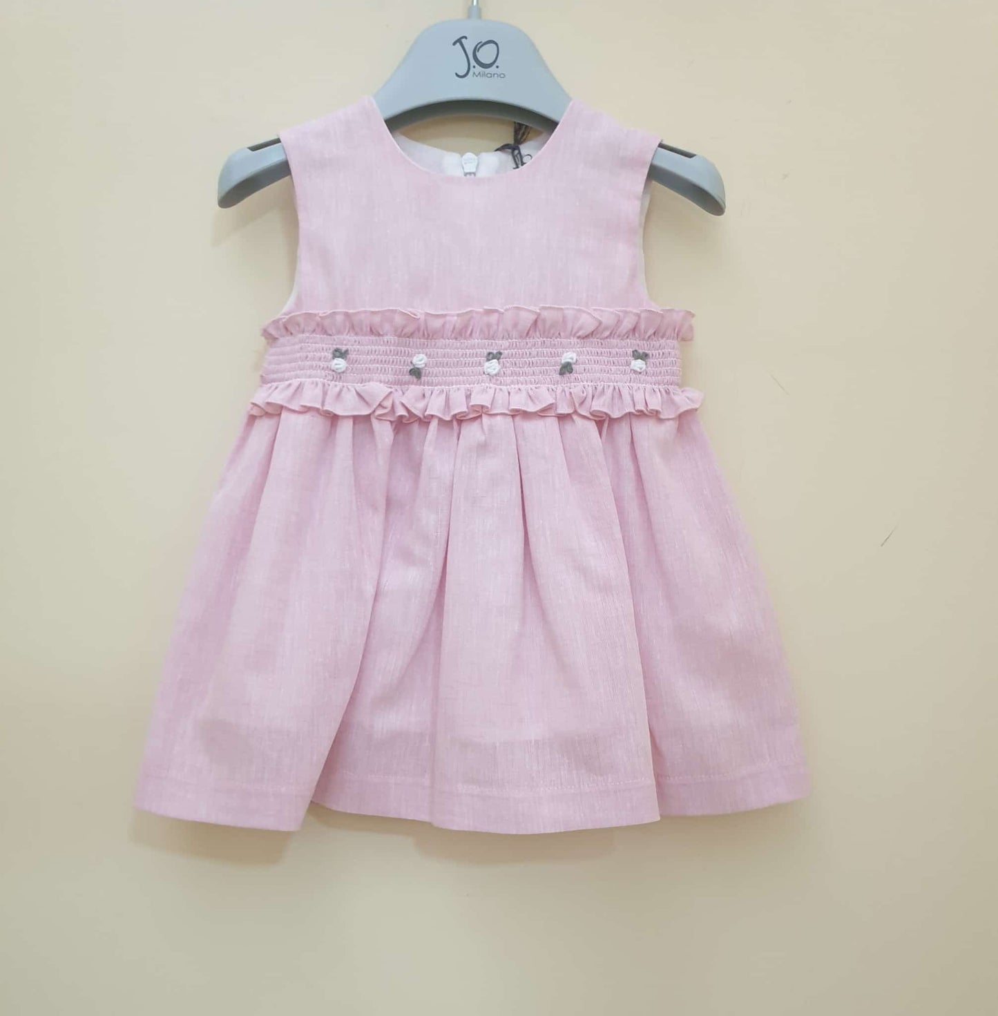 Abito rosa in lino, punto a smock con fiorellini bianchi.